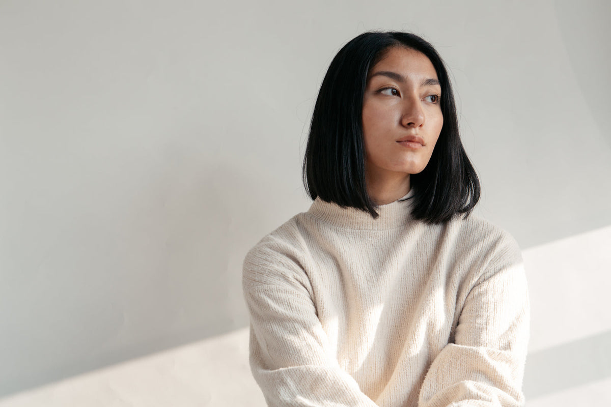Model in neutrale kleuren bij raam